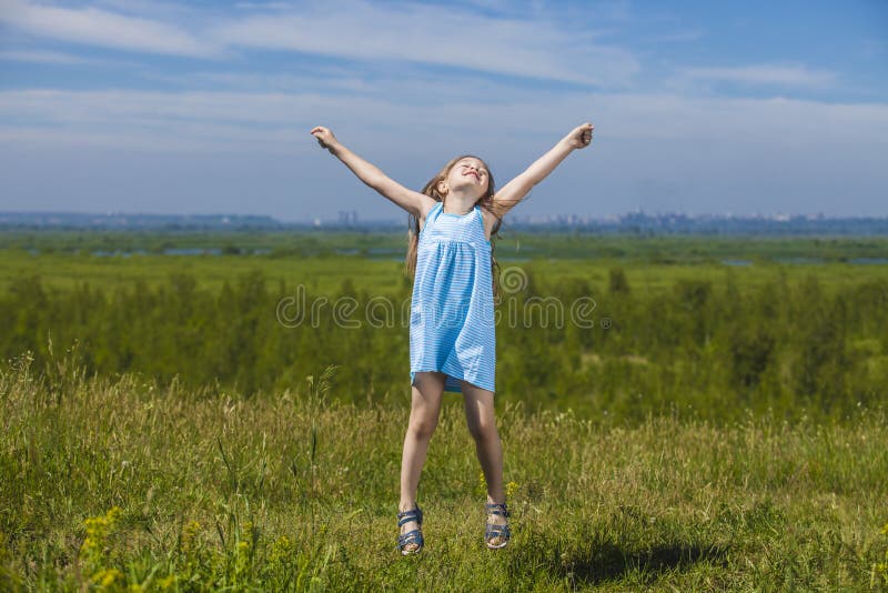 Baby girl jumping on a meadow