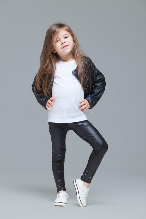 Baby Girl with Long Hair in Black Leather Jacket and Leggings is Standing  in the Studio on Grey Background Stock Photo - Image of expression, cute:  180692888