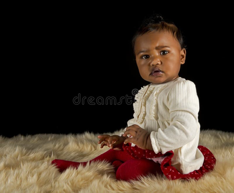 Baby girl sitting on a fur rug