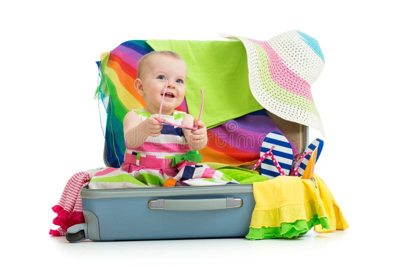 Baby girl sitting in suitcase for vacation travel