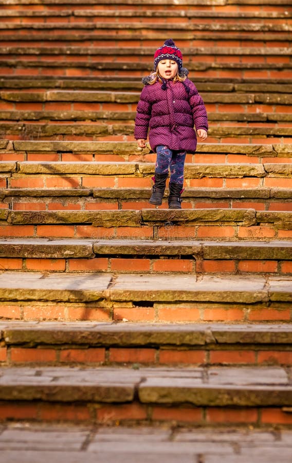 Baby girl walking down old stairs
