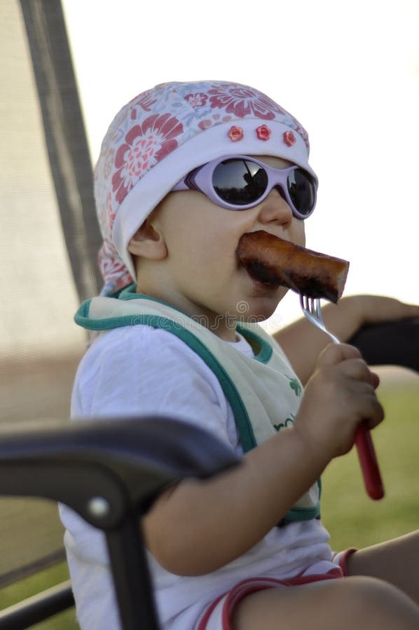 Baby with grilled sausage
