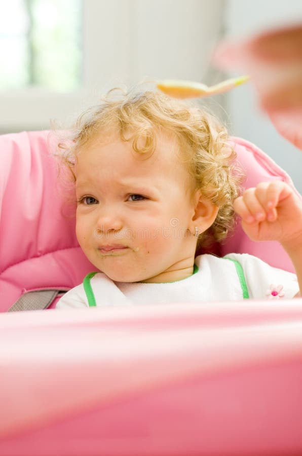 Lindo pequeno un nino de acuerdo su madre cuchara, triste expresión, ella tiene no querer sobre el comer.