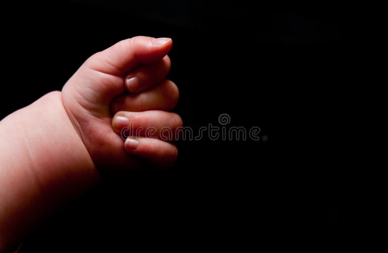 Baby hand on black