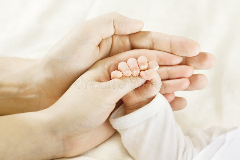 Primo piano del bambino per mano i genitori mani.