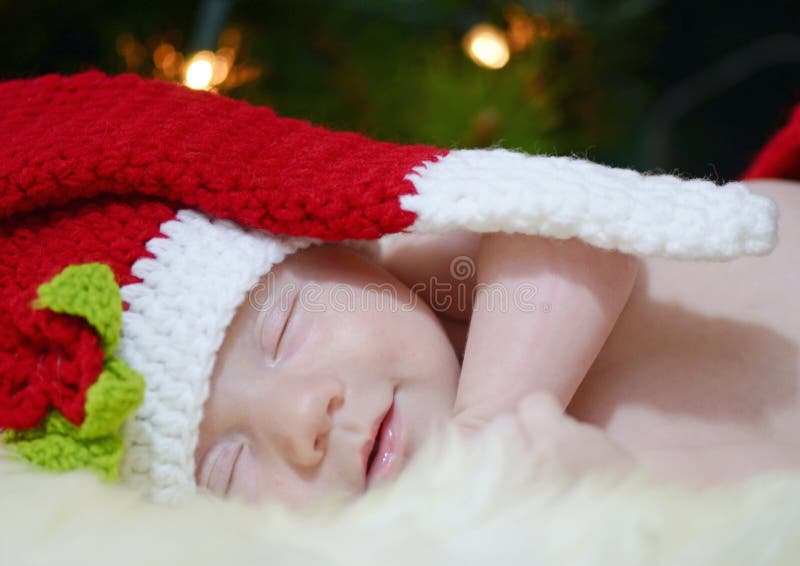 A close up portrait of an adorable little infant girl sleeping and smiling in her sleep, no doubt dreaming about Santa Claus. It is only the young at heart that believe in magic. A close up portrait of an adorable little infant girl sleeping and smiling in her sleep, no doubt dreaming about Santa Claus. It is only the young at heart that believe in magic.
