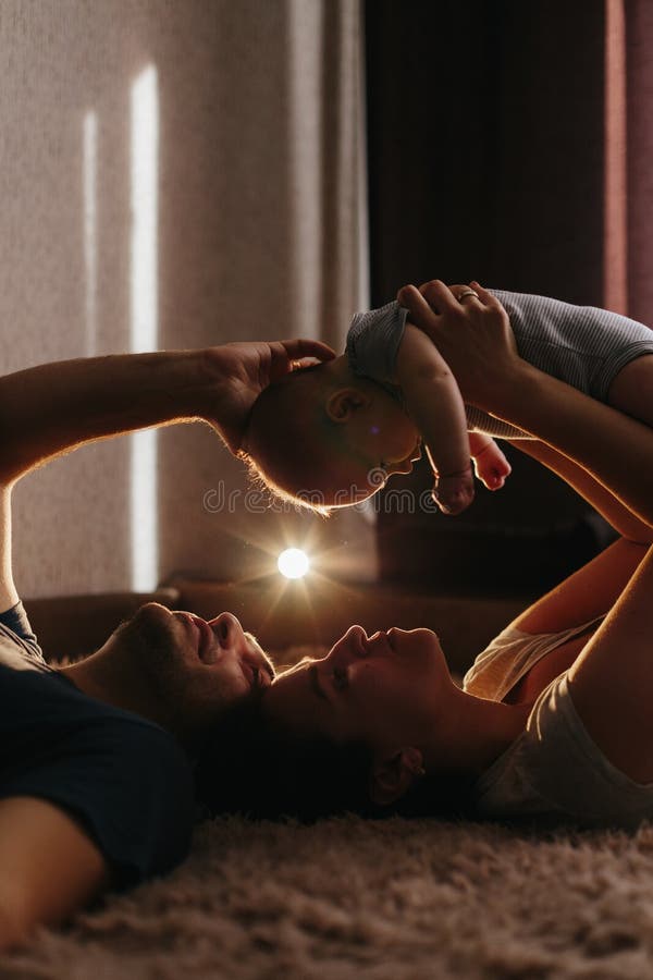 Baby with his parents playing on the bed. Happy family at home. Lifestyle cozy photos. Little boy 4 months old stock photos Baby with his parents playing on the bed. Happy family at home. Lifestyle cozy photos. Little boy 4 months old stock photos