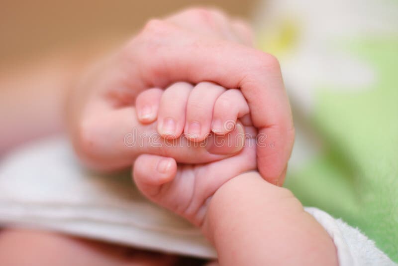 Baby hold mother finger in hand