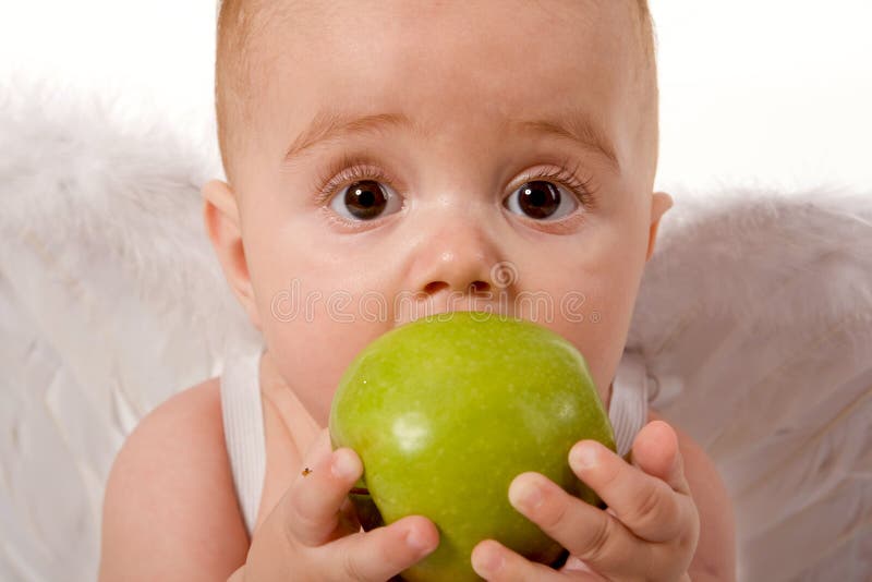 Baby holding and eating an apple