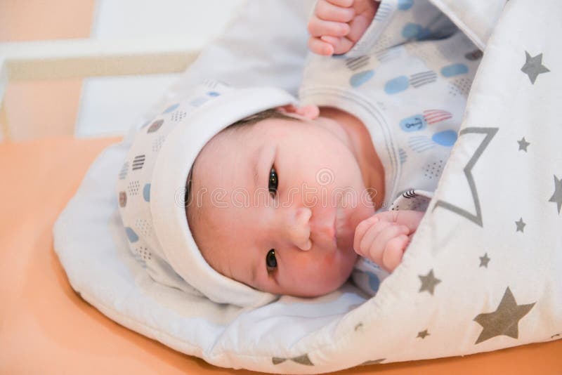 Baby in the hospital, lying on the sofa, wrapped in a blanket, discharge of the child from the maternity hospital, birth of the stock photos Baby in the hospital, lying on the sofa, wrapped in a blanket, discharge of the child from the maternity hospital, birth of the stock photos
