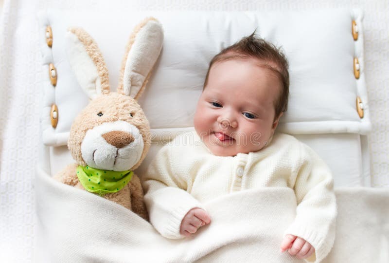 Baby im Bett mit Häschenspielzeug stockfotos Baby im Bett mit Häschenspielzeug stockfotos