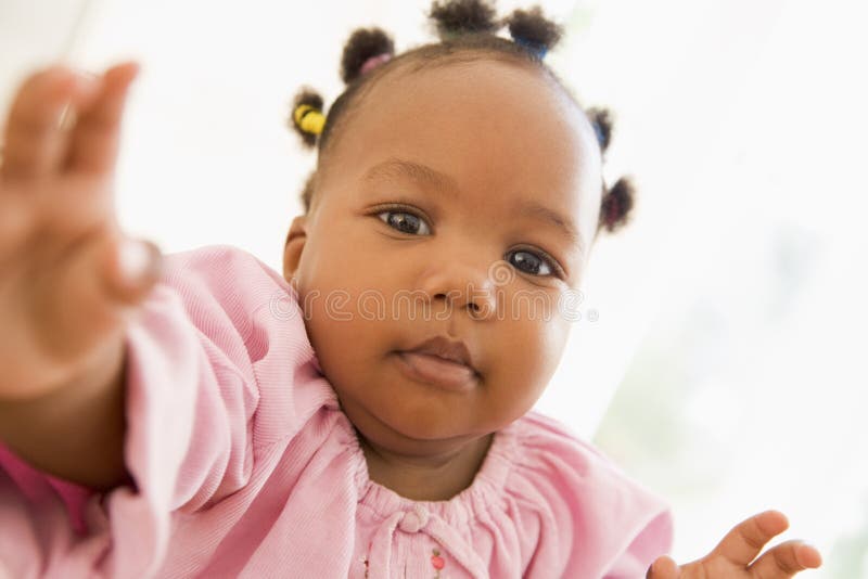 Baby indoors reaching hand out