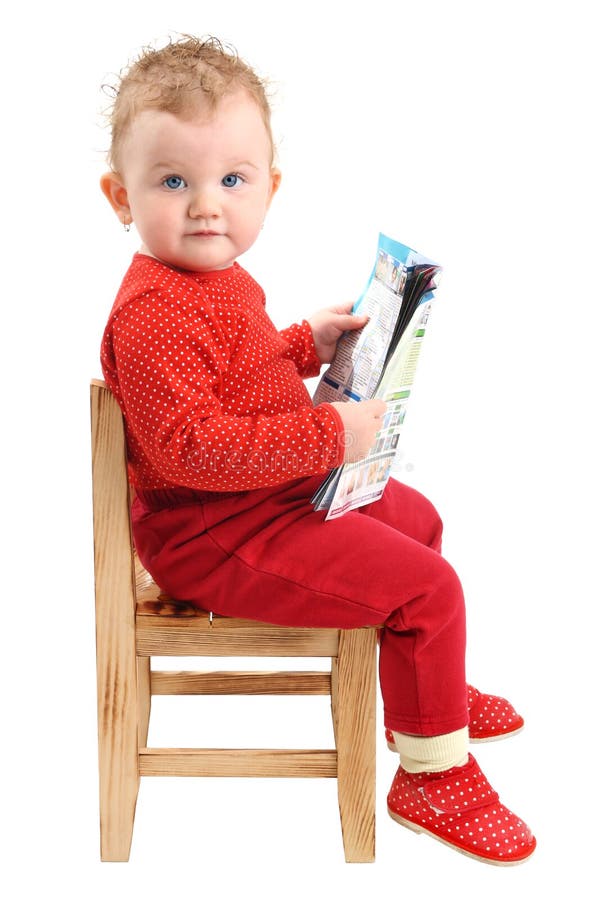 Whole body portrait of sitting baby girl dressed in red clothes, looking at camera, with some papers in her hands, isolated on white background. Whole body portrait of sitting baby girl dressed in red clothes, looking at camera, with some papers in her hands, isolated on white background