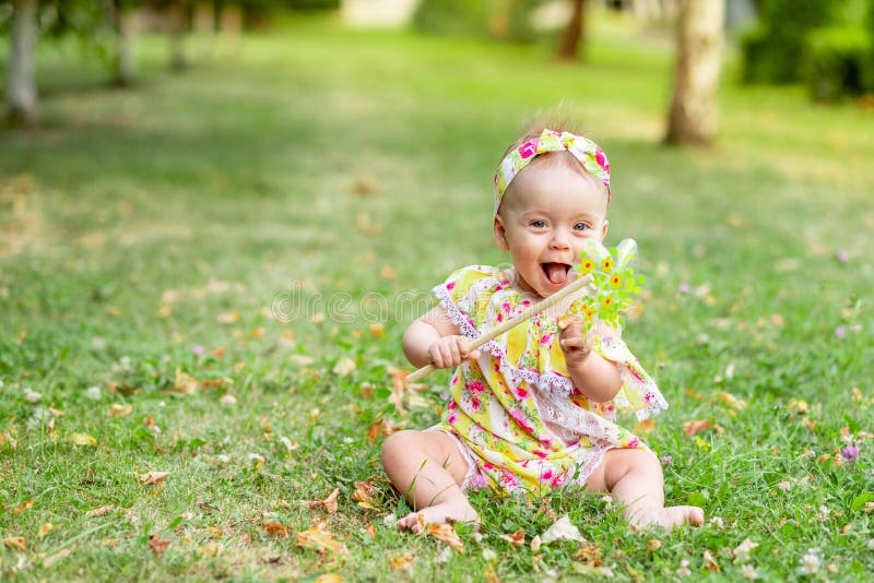 Baby on the Lawn Walks in the Summer in Yellow Clothes Stock Photo