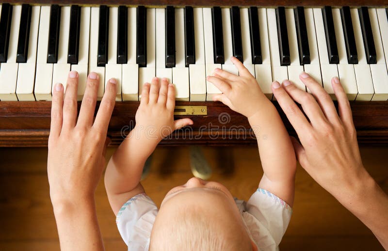 Primo piano ritratto di un bambino impara a suonare il pianoforte con la madre dall'alto.