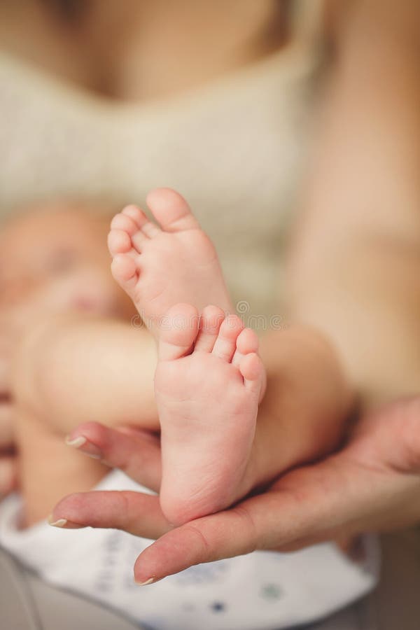 Baby legs. Newborn feet in the hands of her mother