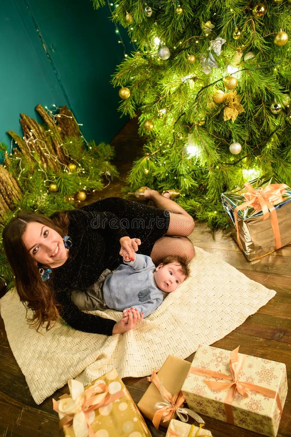 Baby with mother at Christmas. happy family mother and baby little son playing home on Christmas holidays. New Year`s holidays. stock photo Baby with mother at Christmas. happy family mother and baby little son playing home on Christmas holidays. New Year`s holidays. stock photo