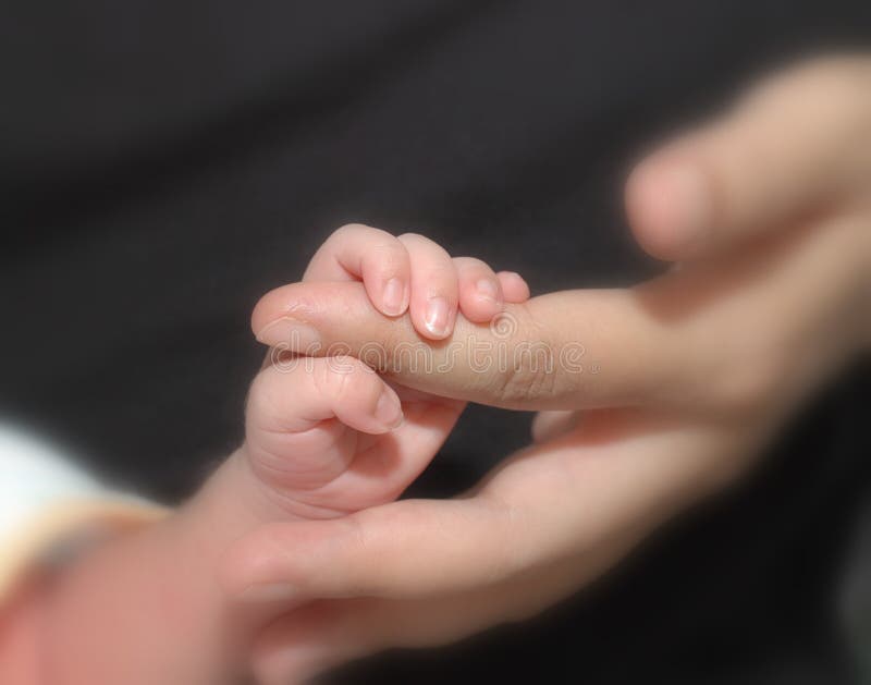 Un nino a madre mano en selectivo suave concentrarse.