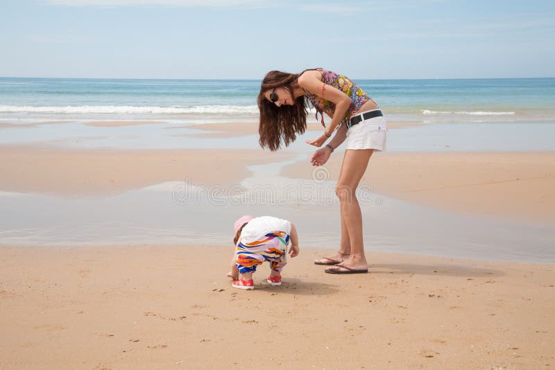 Baby and mother looking for sea shells