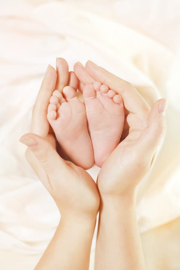 Baby Newborn Feet in Mother Hands. Beautiful New Born Kid Foot, Family Love Concept