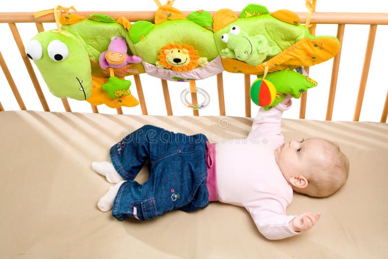 Baby lying on back on bed palying, white background. Lovely european female stock images, royalty-free photos and pictures