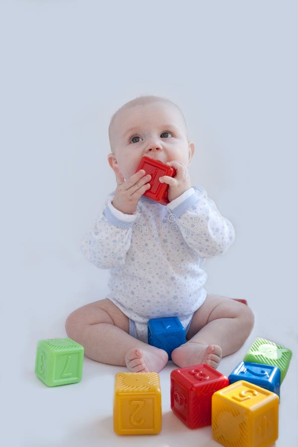 The baby plays with the multi-coloured cubes