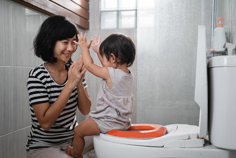 baby pup clapping jokingly with his mother against the background of the toilet