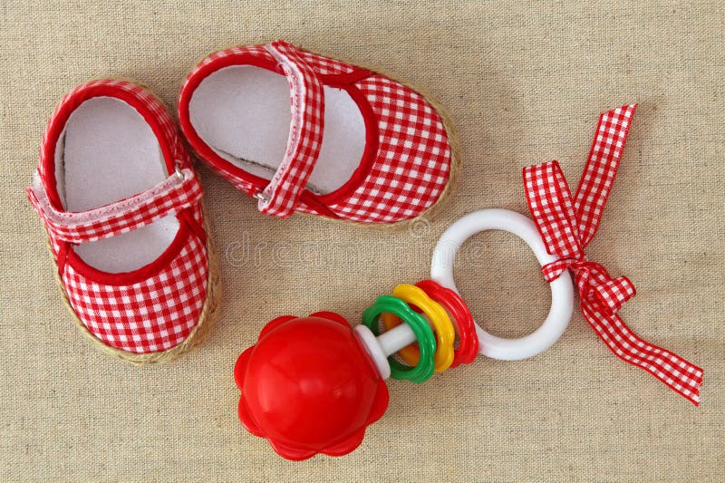 Baby rattle and red shoes royalty free stock photos