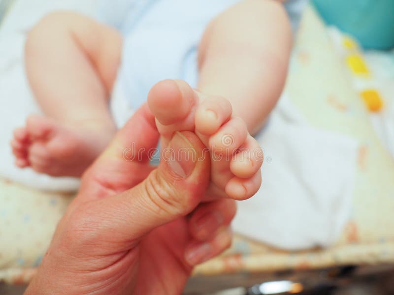 Baby receiving thumb under foot massage after diaper change