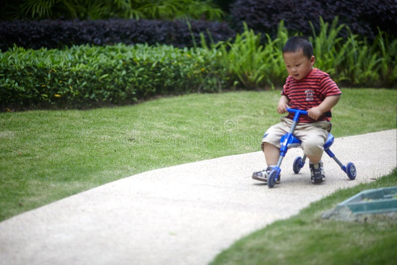 Happy young boy rides his tricycle. Happy young boy rides his tricycle