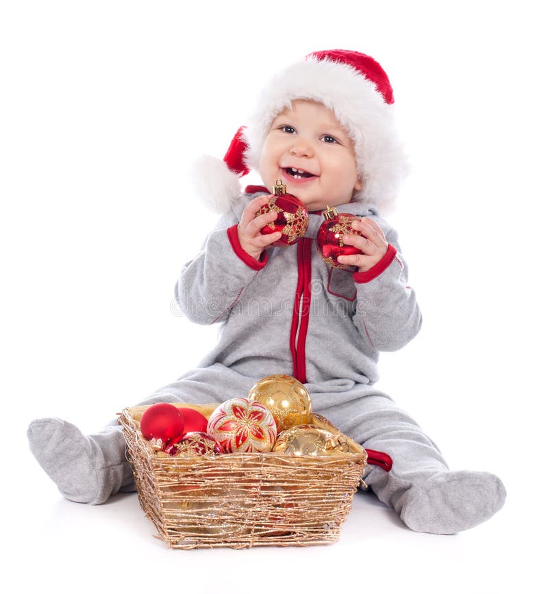 Baby in Santa hat playing with Christmas balls