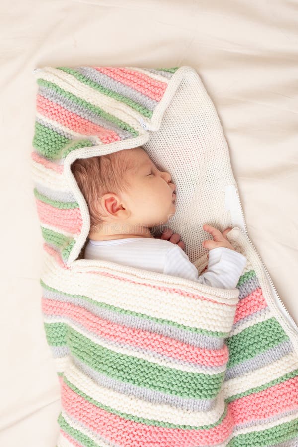 Baby schläft in farbiger Strickdecke stockbilder