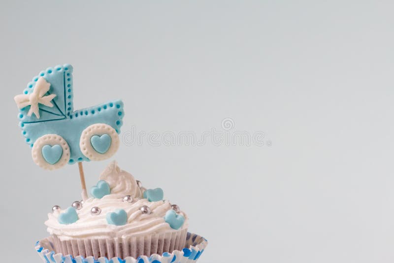 It`s a boy cupcake, close up. Newborn background. Baby shower invitation. Baby announcement. Fondant baby accessories. Text space. It`s a boy cupcake, close up. Newborn background. Baby shower invitation. Baby announcement. Fondant baby accessories. Text space