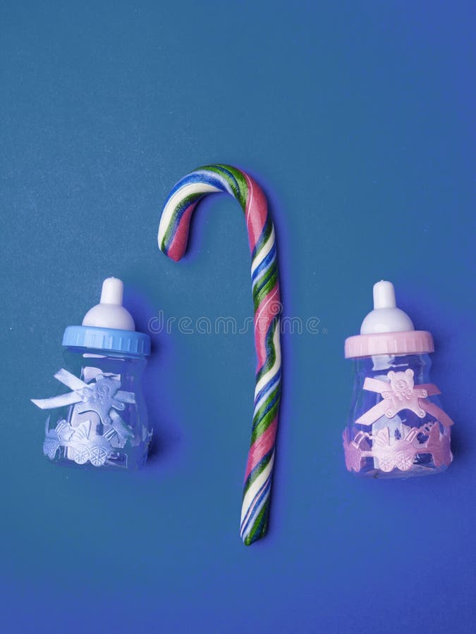 Baby Shower greeting card with babies boy and girl toy bottles and candy cane, baby announcement card design element, or newborn greeting card. copy space, top view