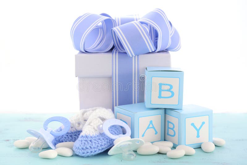 Baby shower Its a Boy blue gift, with gift box, baby booties and dummy on pale blue shabby chic rustic wood table.