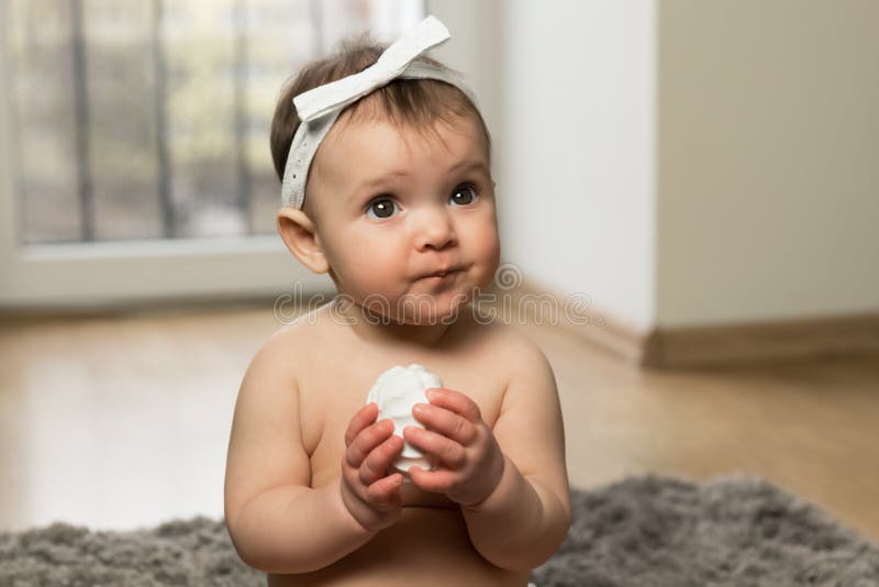 The Baby Sits on the Floor in the Diaper and Eats Marshmallows Stock