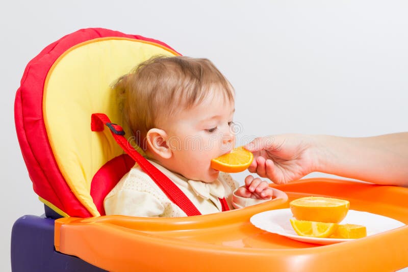 Baby Sits in Highchair with Orange. Stock Image Image of child