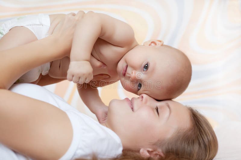 Baby of six months old in his mothers hands.