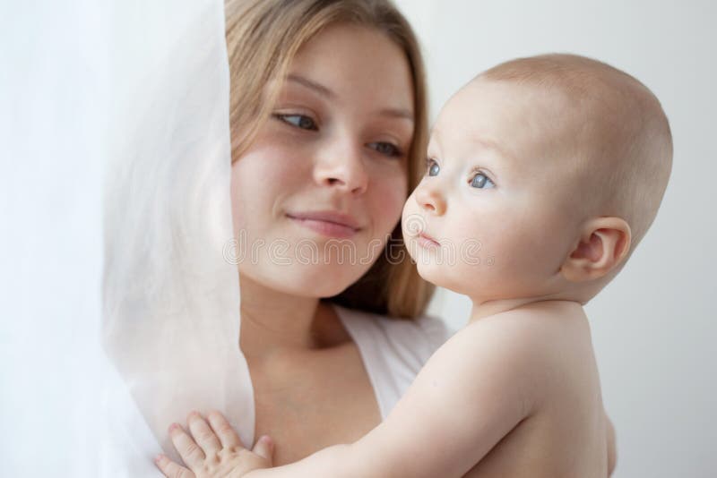 Baby of six months old in his mothers hands.