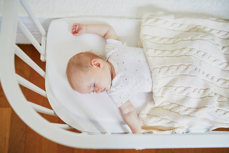 Baby sleeping in co-sleeper crib attached to parents` bed royalty free stock photography Baby sleeping in co-sleeper crib attached to parents` bed royalty free stock photography