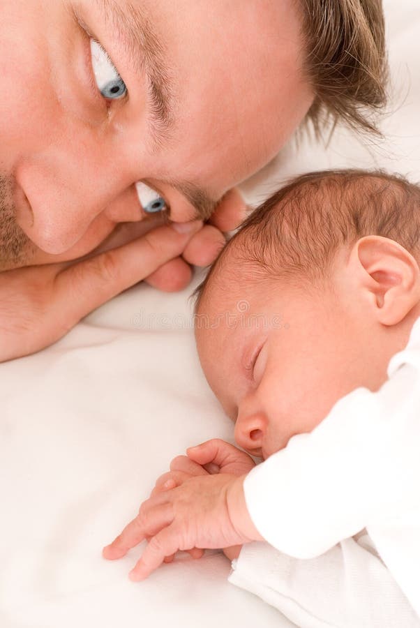 Baby sleeps next to his father