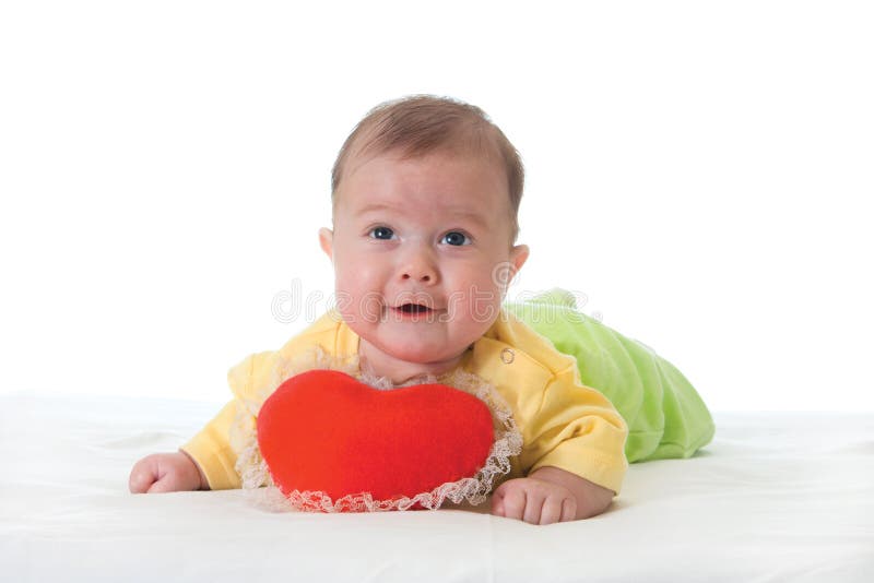 Baby with a soft toy in the form of heart