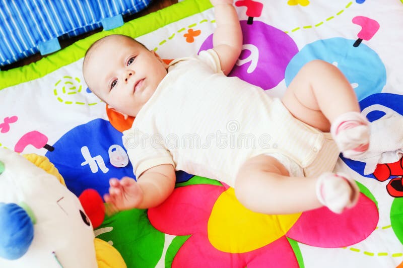 Baby som ligger på den framkallande filten arkivbild Baby som ligger på den framkallande filten arkivbild