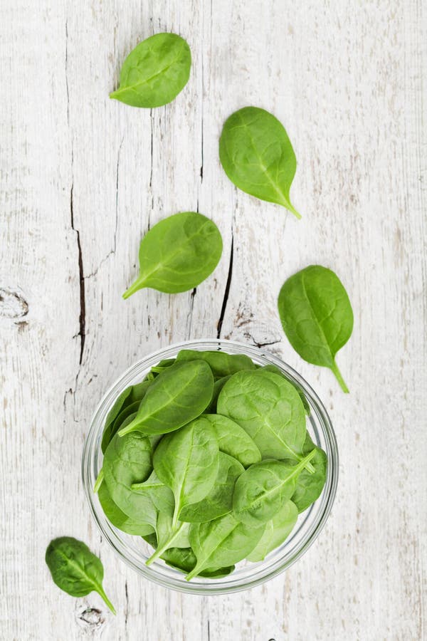 Green Baby Spinach Leaves in Wooden Bowl on Rustic Stone Table Top View