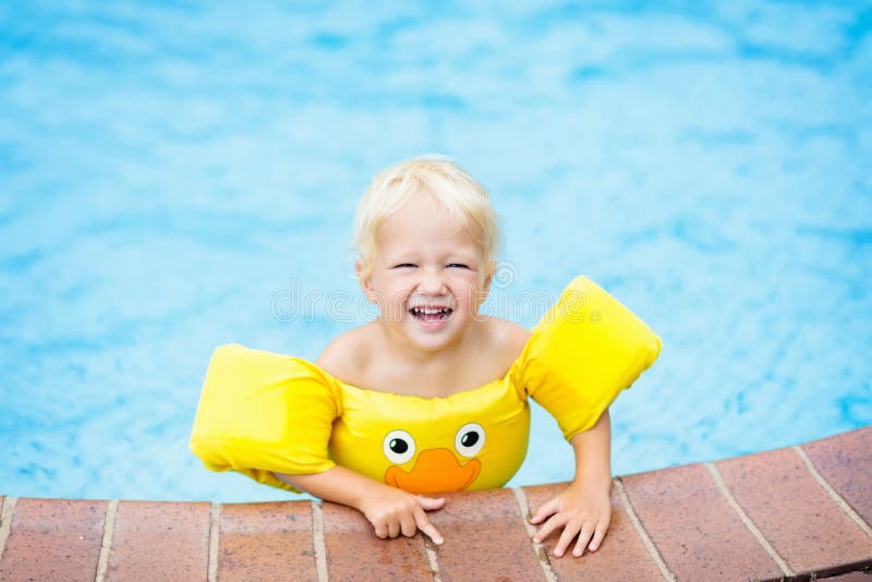 Baby in swimming pool. Kids swim aid.