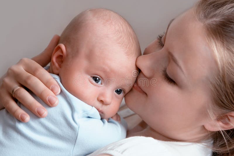 Baby of three months old in his mothers hands.