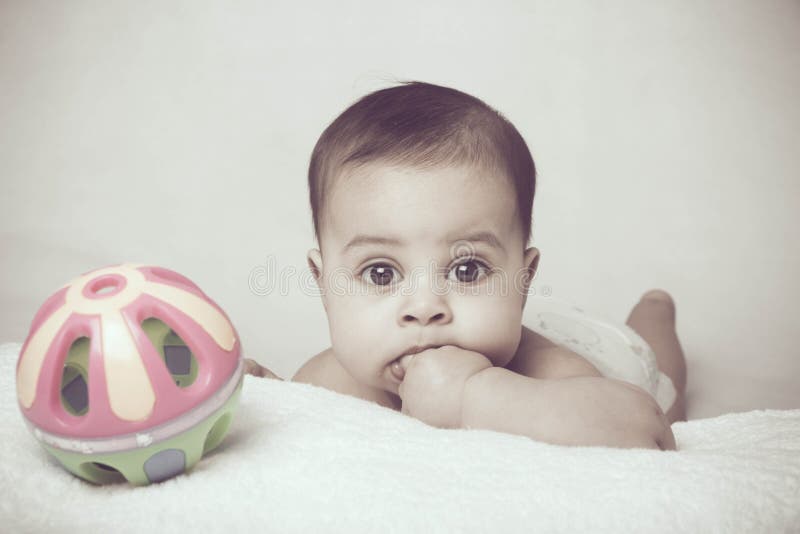 Bambino sul letto con il suo giocattolo.