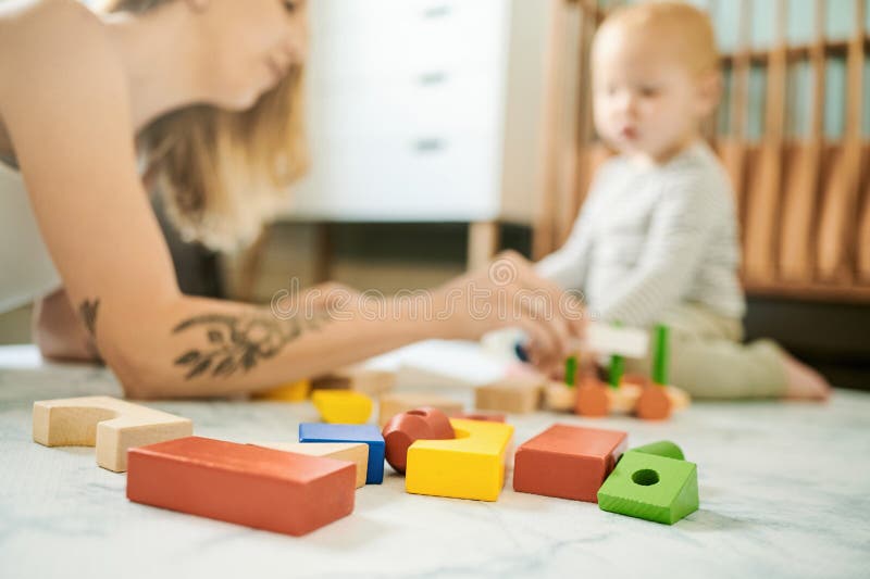 Baby toys, building blocks and mother playing with a child in a family home bedroom for fun. Woman or mom with toddler royalty free stock photography