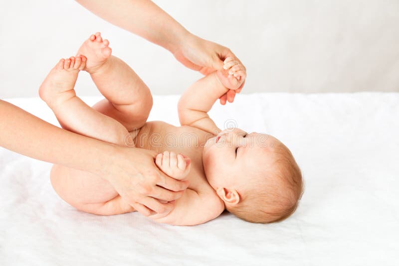 The baby trains the muscles of the hands holding and pulling up. masseuse doing massage baby. stock photo The baby trains the muscles of the hands holding and pulling up. masseuse doing massage baby. stock photo