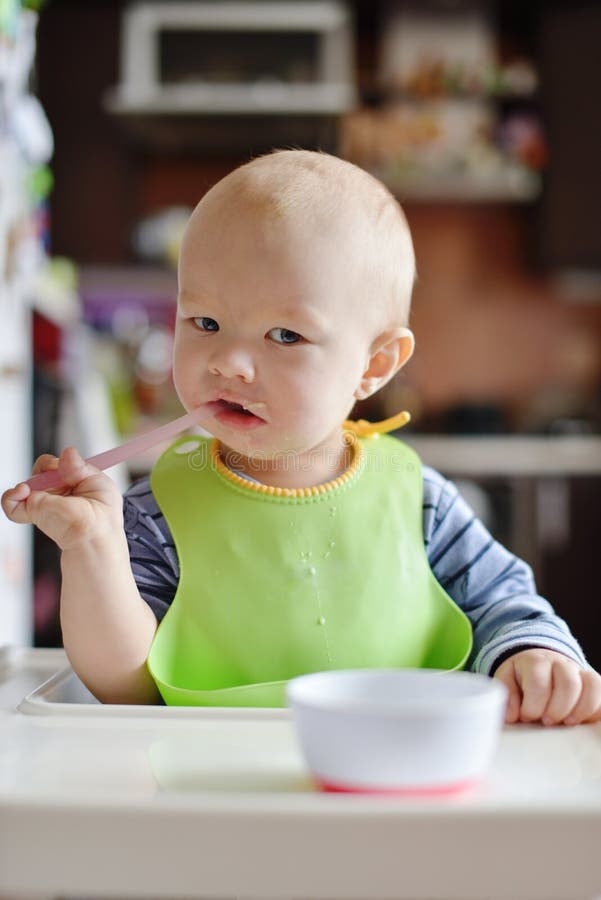Baby trying to eat stock image. Image of meal, chair - 116298755